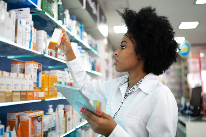 A pharmacist checks inventory with a digital tablet at the pharmacy