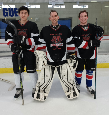 Three Kinaxis hockey team members in hockey uniforms standing left to right on the ice: Richard Fan, Jody Hisko and Michael Whitford.