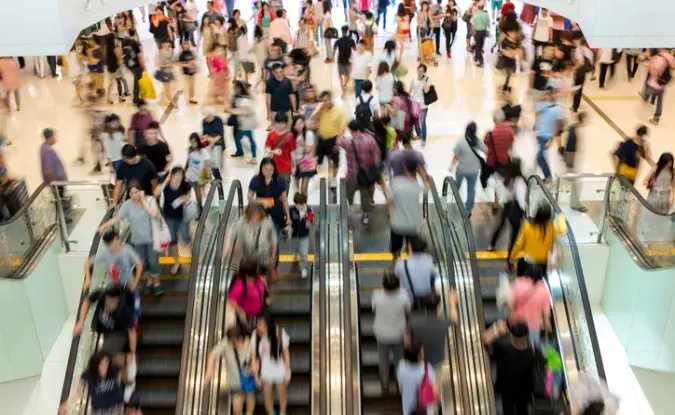 Shoppers riding a crowded escalator.