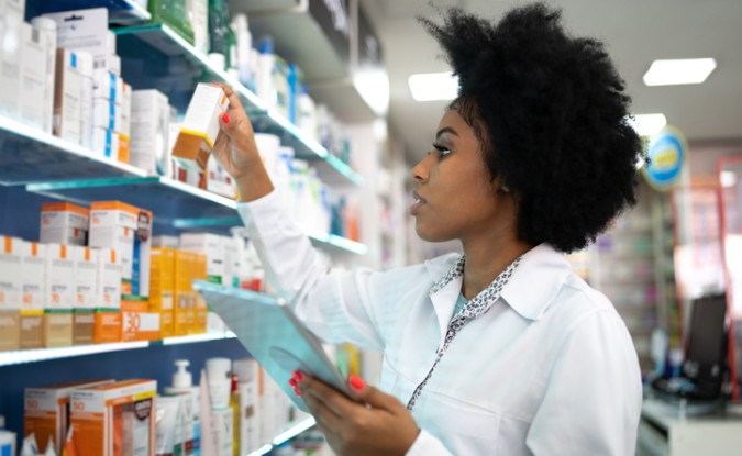 A pharmacist checks inventory with a digital tablet at the pharmacy