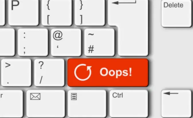 Closeup of white computer keyboard, focusing on a red button labled "Oops!" with a reload symbol.