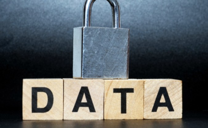 Photo of a padlock placed on top of four wood blocks, which spell out "DATA"