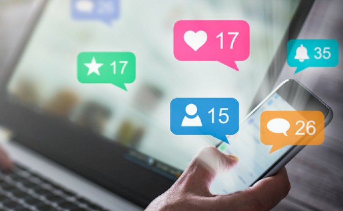 Like and share social media. Hands holding smartphone with social media network icons.