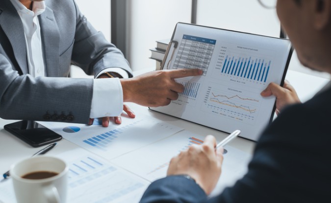 Supply chain leader speaking with CFO, displaying charts and graphs