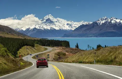 Car driving in a road and a mountain in the back