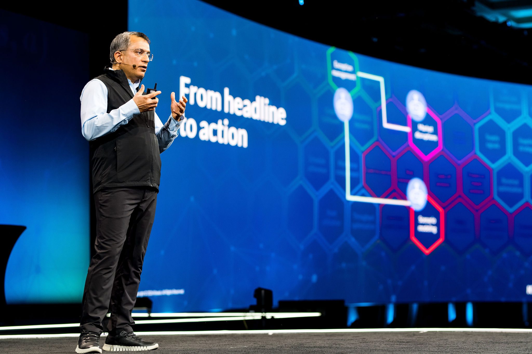 Chief of Agentic Solutions, Manik Sharma speaks to the Kinexions participants in front of a presentation that says, "From headline to action"