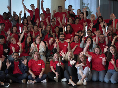 Large group of enthusiastic, happy Kinaxis employees wearing red Kinaxis T-shirts